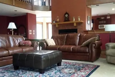 a living room with a leather couch and a table at Romantic Room Rental on a Lovely Farm near Hillsboro, Ohio