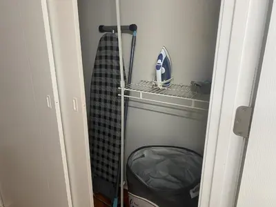 a closet with a black and white robe and a shelf at Bachome in Kettering