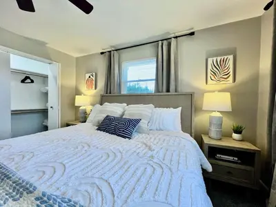 a bedroom with a large white bed with two pillows at All the Vibes Poolside in Trenton in Trenton