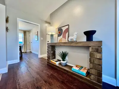 a living room with a brick fireplace in a house at All the Vibes Poolside in Trenton in Trenton