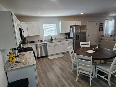 a kitchen and living room with a table and a dining room at Cozy New Const. Ranch Near Park in Middletown