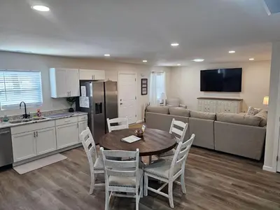 a kitchen and living room with a table and a couch at Cozy New Const. Ranch Near Park in Middletown