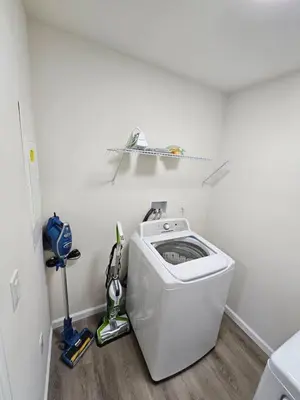 a laundry room with a washing machine in the corner at Cozy New Const. Ranch Near Park in Middletown