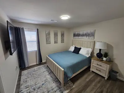 a bedroom with a blue bed and a window at Cozy New Const. Ranch Near Park in Middletown