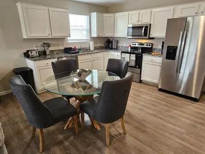 a kitchen with a glass table and chairs and a refrigerator at Beautiful NEW Wilmington Ranch in Wilmington