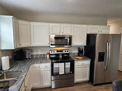 a kitchen with white cabinets and stainless steel appliances at Beautiful NEW Wilmington Ranch in Wilmington