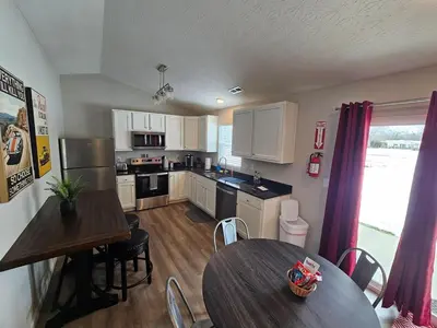 a kitchen with a table and two tables and a kitchen with white cabinets at Vroooom . . . . the ROAD is calling. . . . in Trenton