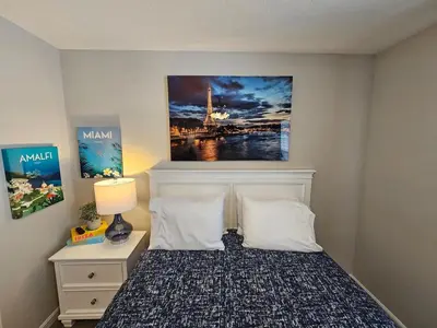 a bedroom with a bed with a painting on the wall at And . . . . the Beat Goes On in Trenton