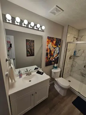 a bathroom with a sink and a toilet and a shower at And . . . . the Beat Goes On in Trenton