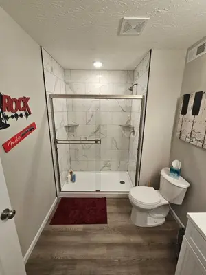 a bathroom with a tub and a toilet and a shower at And . . . . the Beat Goes On in Trenton