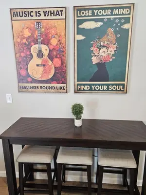 a dining room table with three posters on the wall at And . . . . the Beat Goes On in Trenton