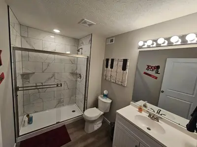 a bathroom with a shower and a toilet and a sink at And . . . . the Beat Goes On in Trenton