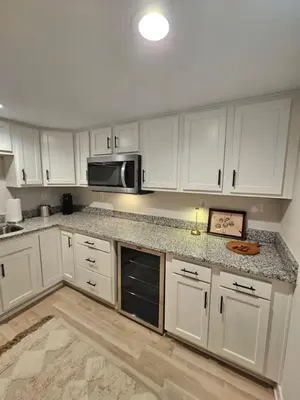 a white kitchen with white cabinets and a microwave at Upscale New Construction Ranch in Middletown