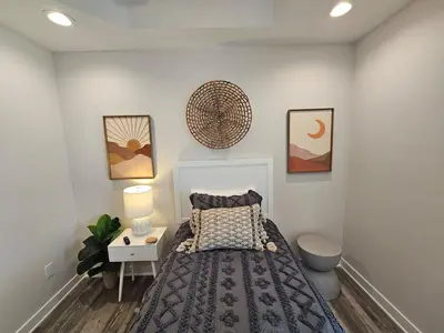 a bedroom with a bed and a table with a night stand at Upscale New Construction Ranch in Middletown