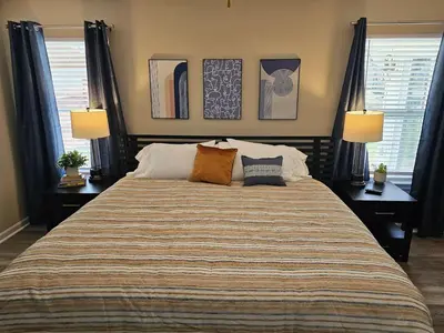 a bedroom with a large bed with two lamps on it at Cozy Charming Cottage-Style Home in Hamilton