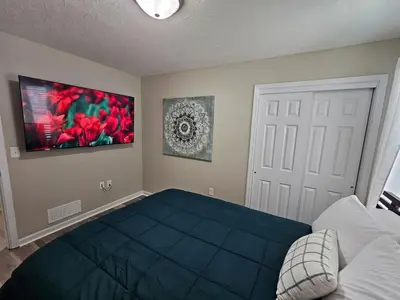 a bedroom with a bed and a painting on the wall at Cozy Charming Cottage-Style Home in Hamilton