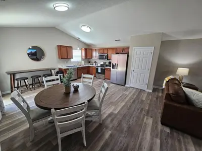 a living room and kitchen with a table and a couch at Cozy Charming Cottage-Style Home in Hamilton