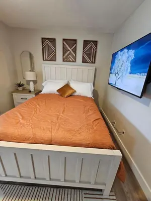 a bedroom with a large bed with an orange blanket at Quaint Liberty Township Remodeled Home in Hamilton