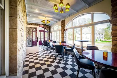 a restaurant with tables and chairs on a checkered floor at Willoughby House Inn in Willoughby
