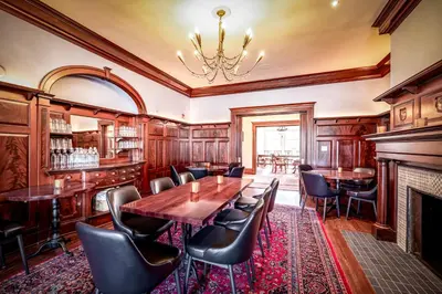 a dining room with a table and chairs and a fireplace at Willoughby House Inn in Willoughby