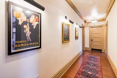 a hallway with posters on the wall and a rug at Willoughby House Inn in Willoughby