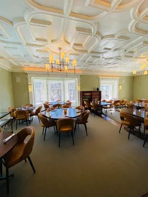a dining room with tables and chairs and a coffered ceiling at Willoughby House Inn in Willoughby