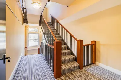 a winding staircase with wooden railings in a home at Willoughby House Inn in Willoughby
