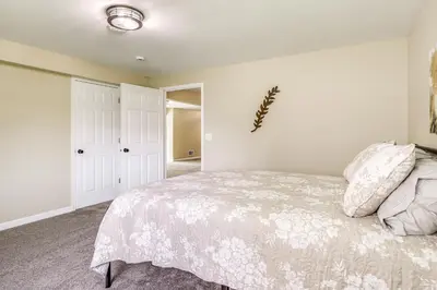 a bedroom with a bed with a white bedspread at 8 Mi to Ark Encounter Family Home with Deck and Grill in Dry Ridge