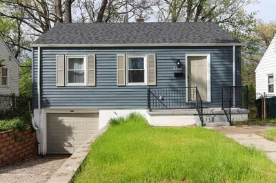 a blue house with a garage in a yard at New Charloe Court 3 Bed Family House in Cincinnati