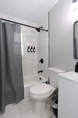 a white bathroom with a toilet and a shower at New Charloe Court 3 Bed Family House in Cincinnati