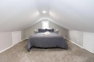 a bedroom with a large bed in a attic at New Charloe Court 3 Bed Family House in Cincinnati