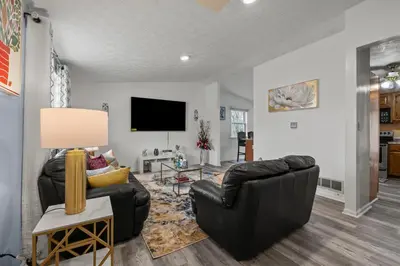 a living room with two black leather chairs and a flat screen tv at Cosy house, home away from home in Grove City