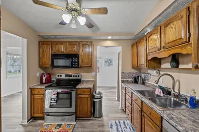 a kitchen with wooden cabinets and a ceiling fan at Cosy house, home away from home in Grove City