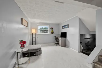 a living room with a table and a chair at Cosy house, home away from home in Grove City