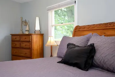a bedroom with a bed with purple sheets and a window at Unique Ohio Cottage for a Weekend Getaway in the Midwest in Perrysville