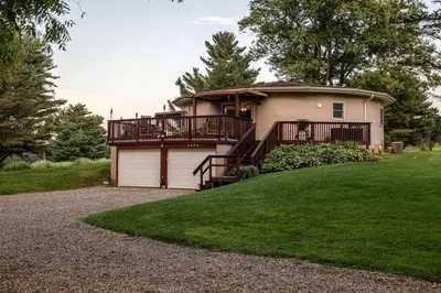 a house with a balcony and a garage at Unique Ohio Cottage for a Weekend Getaway in the Midwest in Perrysville