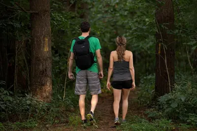 a man and a woman walking down a trail at Unique Ohio Cottage for a Weekend Getaway in the Midwest in Perrysville