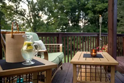 a patio with a table with a vase and a candle at Unique Ohio Cottage for a Weekend Getaway in the Midwest in Perrysville