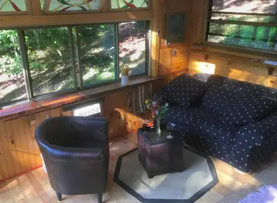 a living room with a couch and a table at Rustic Off-Grid Cabin Getaway near Wayne National Forest, Ohio in Athens