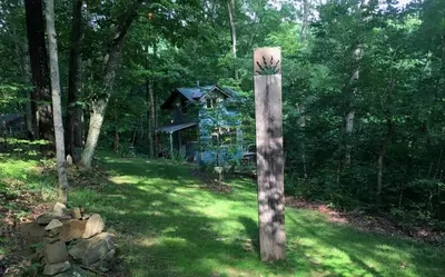 a wooden pole in the grass in front of a house at Rustic Off-Grid Cabin Getaway near Wayne National Forest, Ohio in Athens