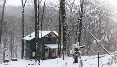 a small house in the woods in the snow at Rustic Off-Grid Cabin Getaway near Wayne National Forest, Ohio in Athens