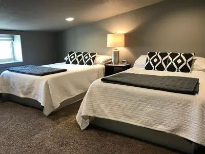 a bedroom with two beds and a lamp at Stunning Rustic Converted Barn Country Getaway near Wabash, Indiana in Wabash
