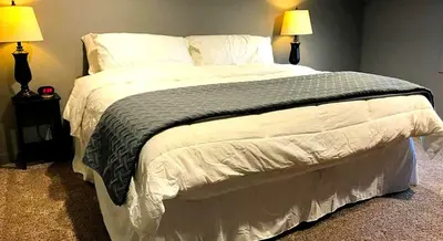 a large bed in a bedroom with two lamps at Stunning Rustic Converted Barn Country Getaway near Wabash, Indiana in Wabash
