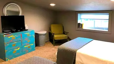 a bedroom with a dresser and a tv and a chair at Stunning Rustic Converted Barn Country Getaway near Wabash, Indiana in Wabash