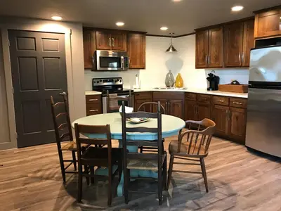 a kitchen with a table and chairs and a refrigerator at Stunning Rustic Converted Barn Country Getaway near Wabash, Indiana in Wabash