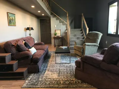 a living room with two couches and a staircase at Stunning Rustic Converted Barn Country Getaway near Wabash, Indiana in Wabash