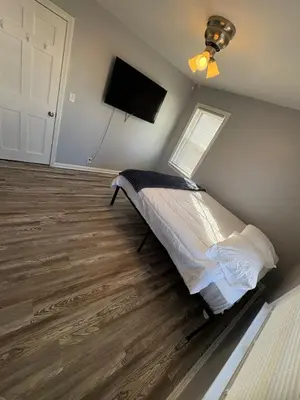 a bedroom with a bed and a flat screen tv at Cozy Euclid Home Near Lakefront in Euclid