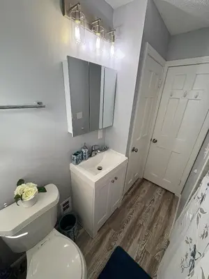 a white bathroom with a toilet and a sink at Cozy Euclid Home Near Lakefront in Euclid