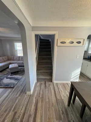 a living room with a staircase and a couch at Cozy Euclid Home Near Lakefront in Euclid