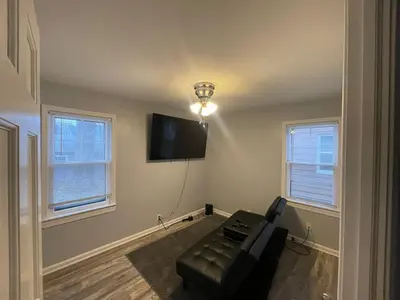 a living room with a couch and a flat screen tv at Cozy Euclid Home Near Lakefront in Euclid
